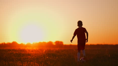Ein-Actionsportbild-Einer-Gruppe-Von-Kindern,-Die-Vor-Sonnenuntergang-Fußball-Spielen,-Um-Sich-Zu-Bewegen
